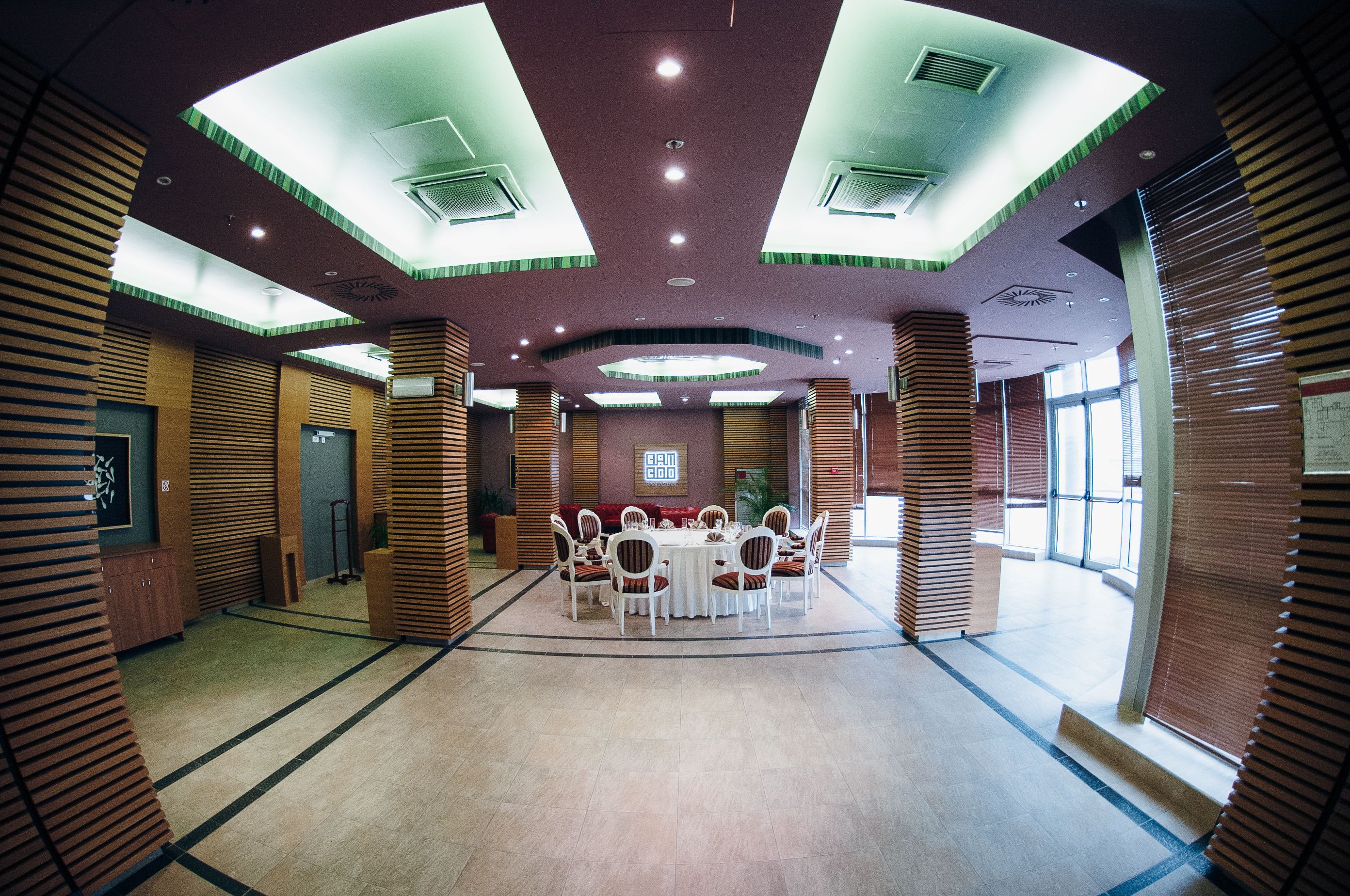A conference room with a round table, chairs, and a large window.