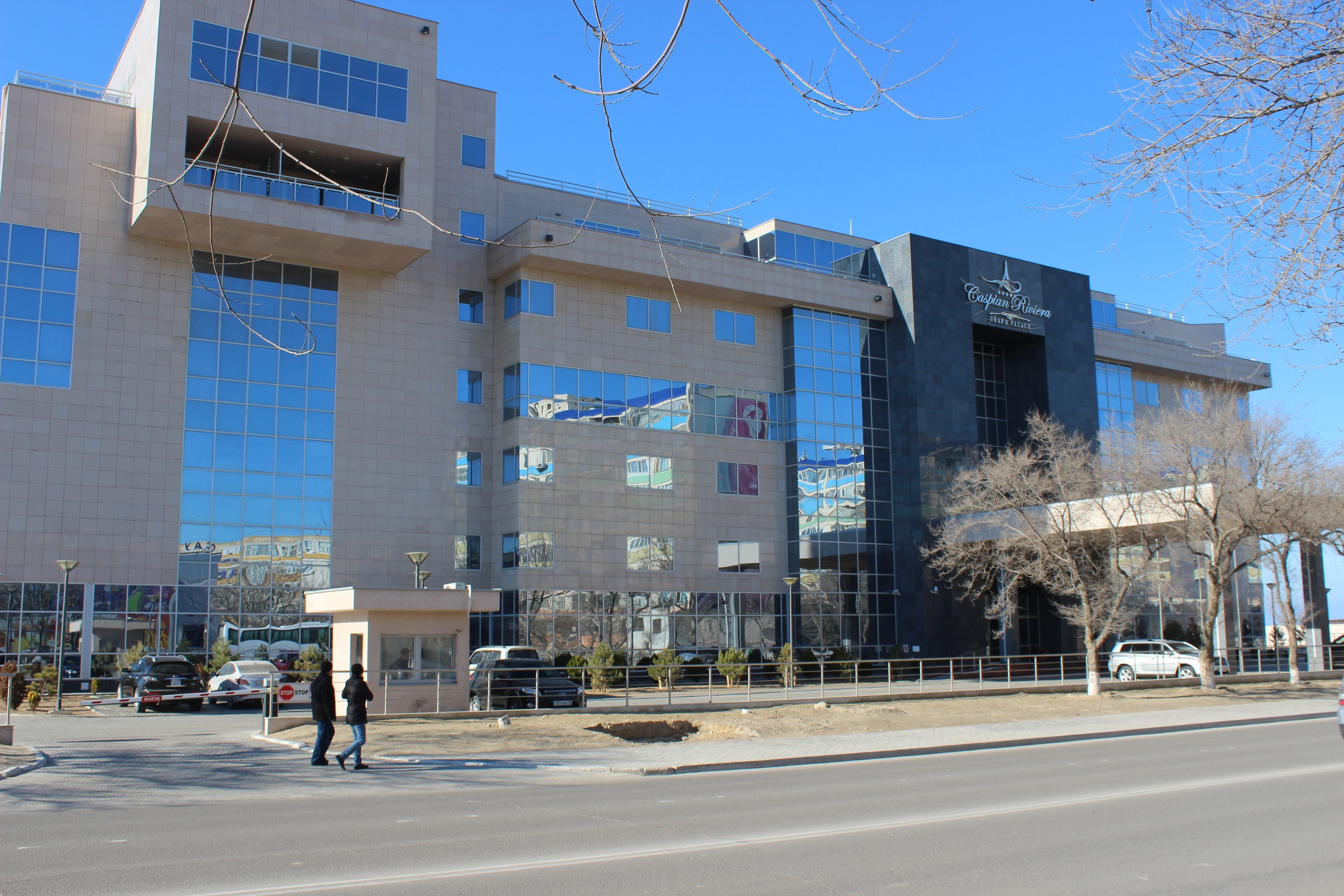 A modern building with multiple floors, large windows, and a sign that reads "Canyon River Resort".
