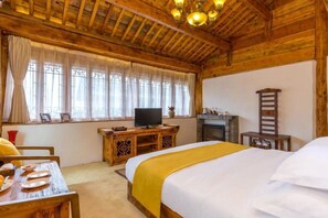 A cozy wooden room with a bed, a television, a fireplace, and a dining table set for breakfast. - Lijiang E Outfitting Boutique Hotel (Lijiang)