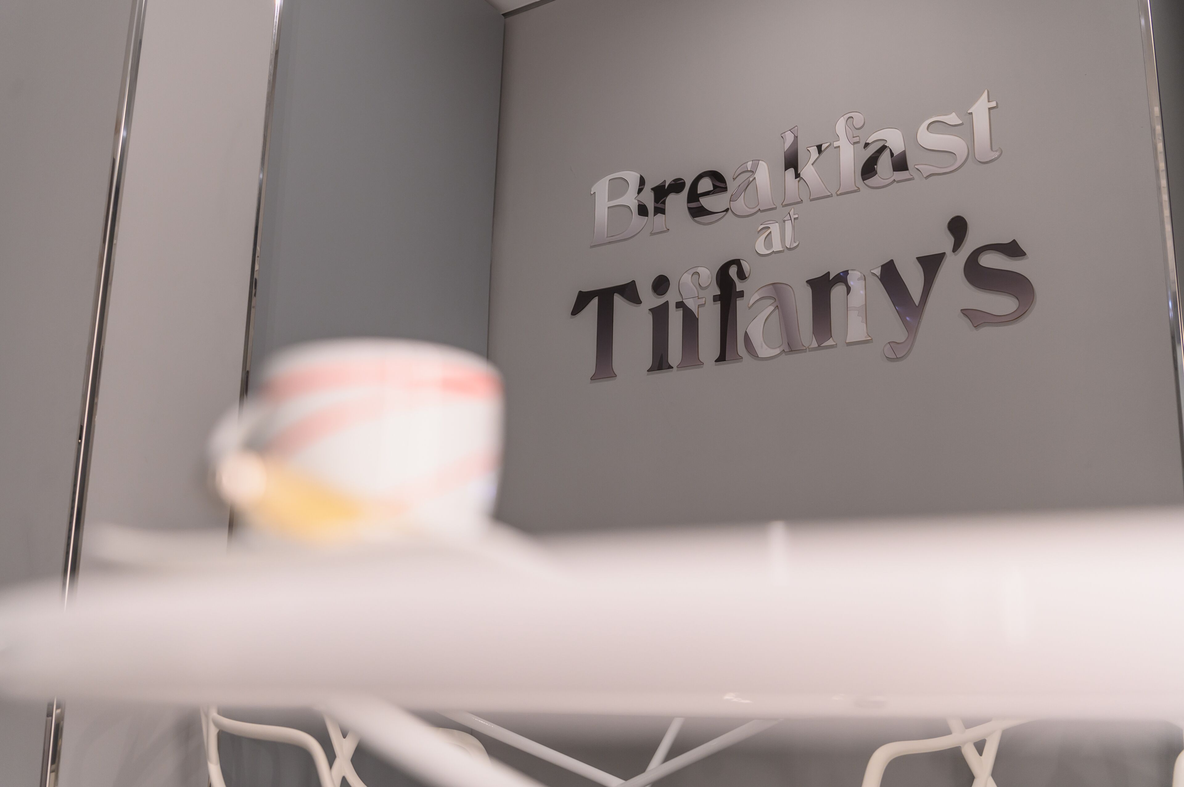 Eine Wand mit dem Schriftzug 'Breakfast at Tiffany's' in einer stilisierten Schrift.