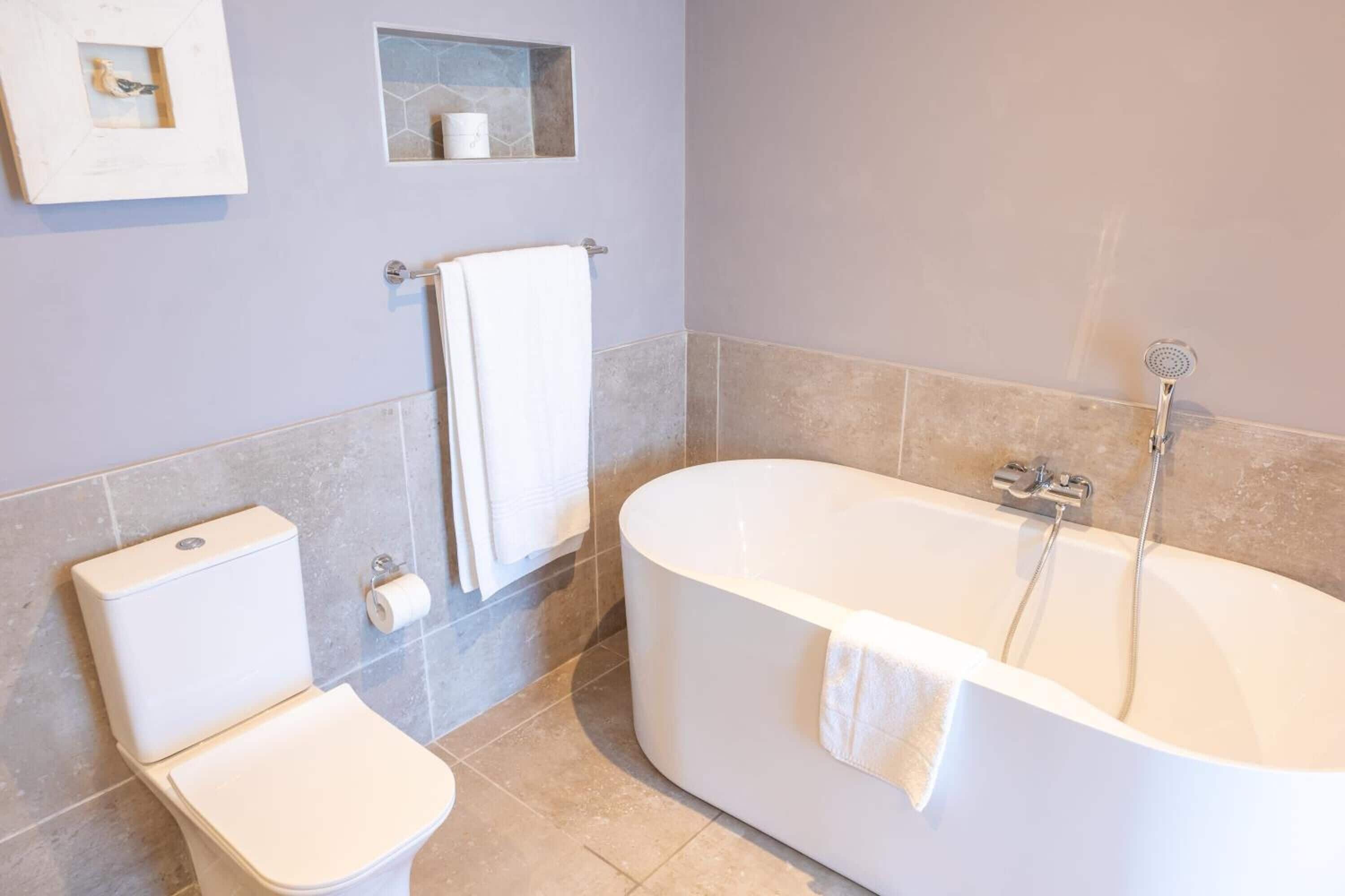 Un baño moderno con inodoro, bañera y ducha.
