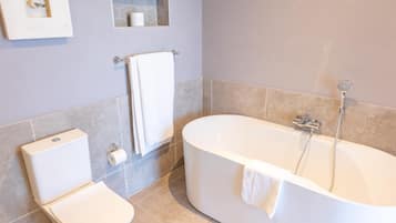Un baño moderno con inodoro, bañera y ducha.