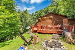A log cabin with a deck, outdoor seating, and a fire pit. - Our secluded Cabin in Maggie Valley, NC (maggie valley)