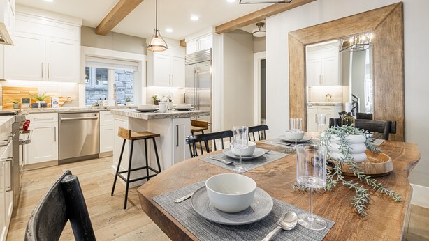 A modern kitchen with white cabinets, a wooden dining table, and a large mirror. - Walk to Trails & Main St, 4BR Hot Tub Home (Park City)