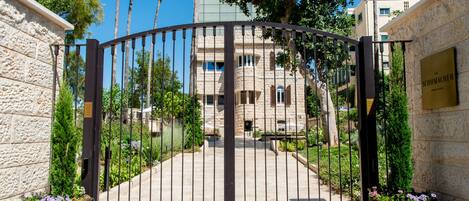 A gated entrance to a building with stone walls and a metal gate.