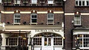 Un bâtiment traditionnel en briques, sur lequel on peut lire l’inscription « TOURIAN LOUNGE ».