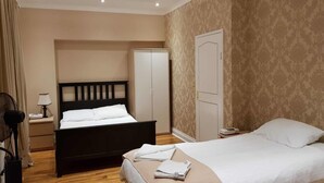 Une chambre d’hôtel avec un lit double, une table de chevet avec une lampe, une armoire et un miroir.