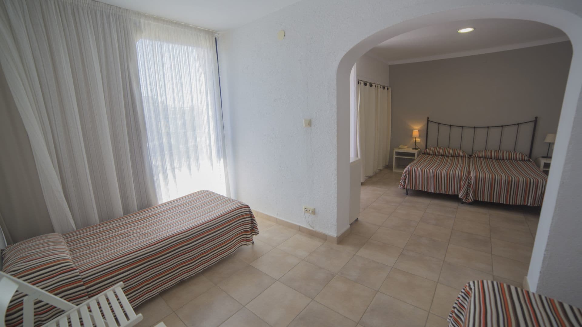 A room with two beds, a small table, and a chair.