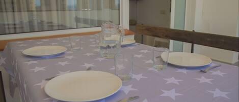 A table set with plates, cutlery, and glasses, with a star-patterned tablecloth.