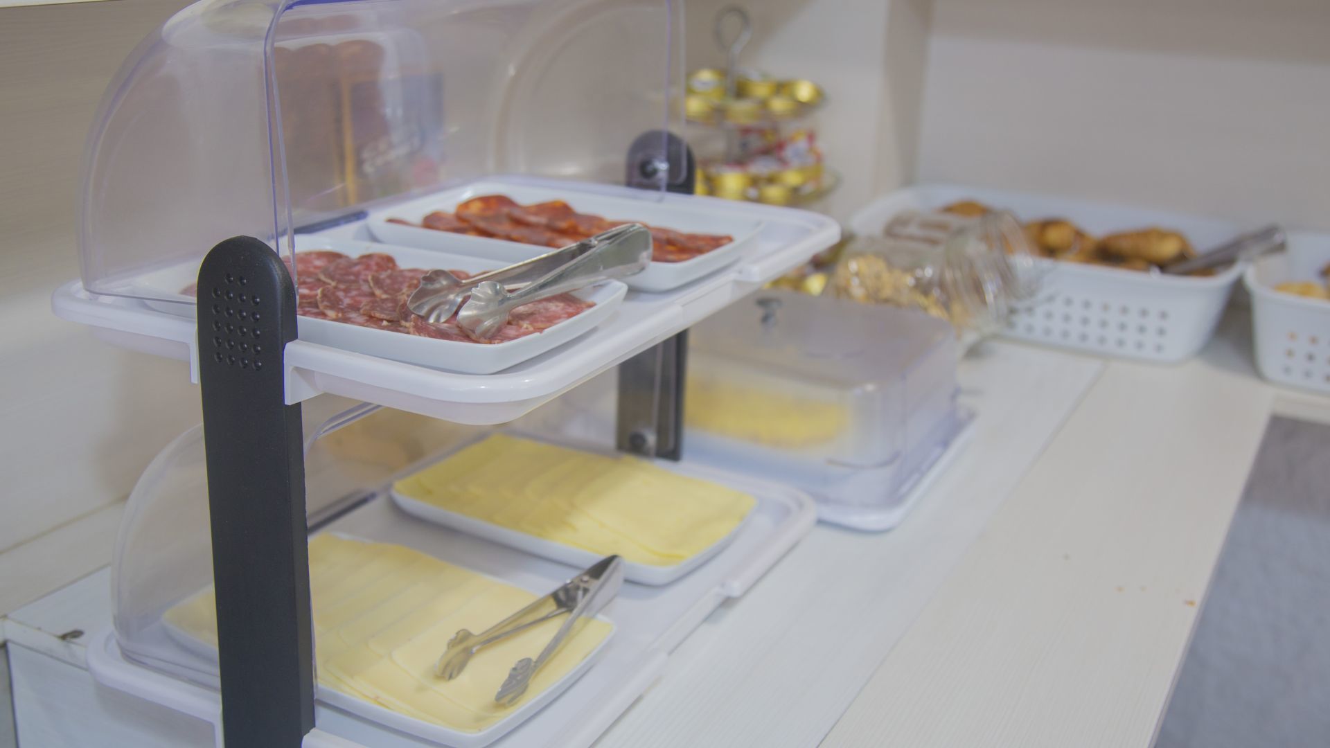 Een buffet met diverse gerechten, waaronder vleesschotels, kazen en gebak.