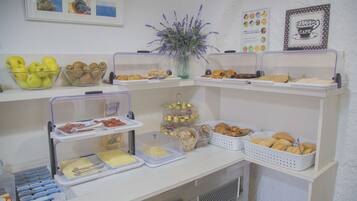 Ein reichhaltiges Buffet mit verschiedenen Speisen, darunter Obst, Gebäck und Soßen.