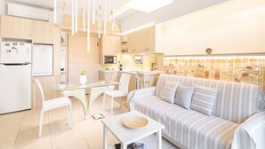A modern kitchen with a dining area, a sofa, and a glass table. - Acropolis Suites 1 - Where else in Athens (Athens)