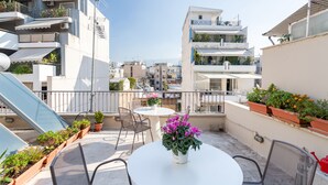 A rooftop terrace with a round table, chairs, potted plants, and a view of the cityscape. - Acropolis Suites 1 - Where else in Athens (Athens)