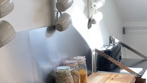 A wooden table with jars and bowls, a toaster, and a kettle on a kitchen counter. - Pisgah Guest House Snowdonia (Blaenau Ffestiniog)