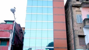 Un hotel llamado "Hotel Crettinn" con una fachada moderna, ventanas grandes y un letrero llamativo en la parte superior.