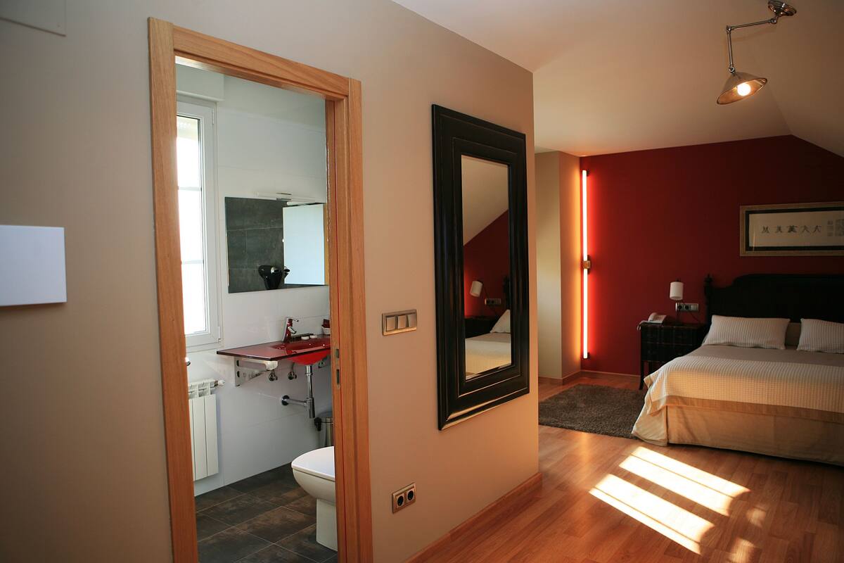 Ein Schlafzimmer mit einem Bett, einem Nachttisch und einer Wandlampe.