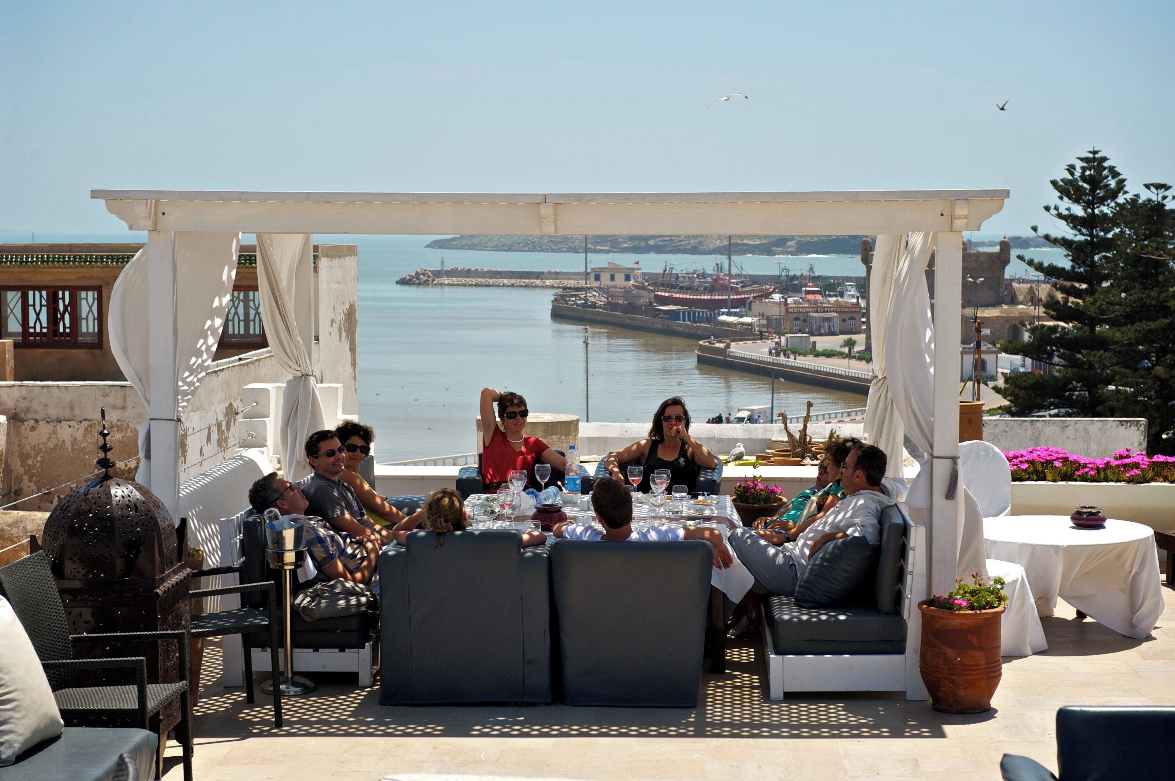 Une terrasse avec des places assises extérieures donnant sur un port.