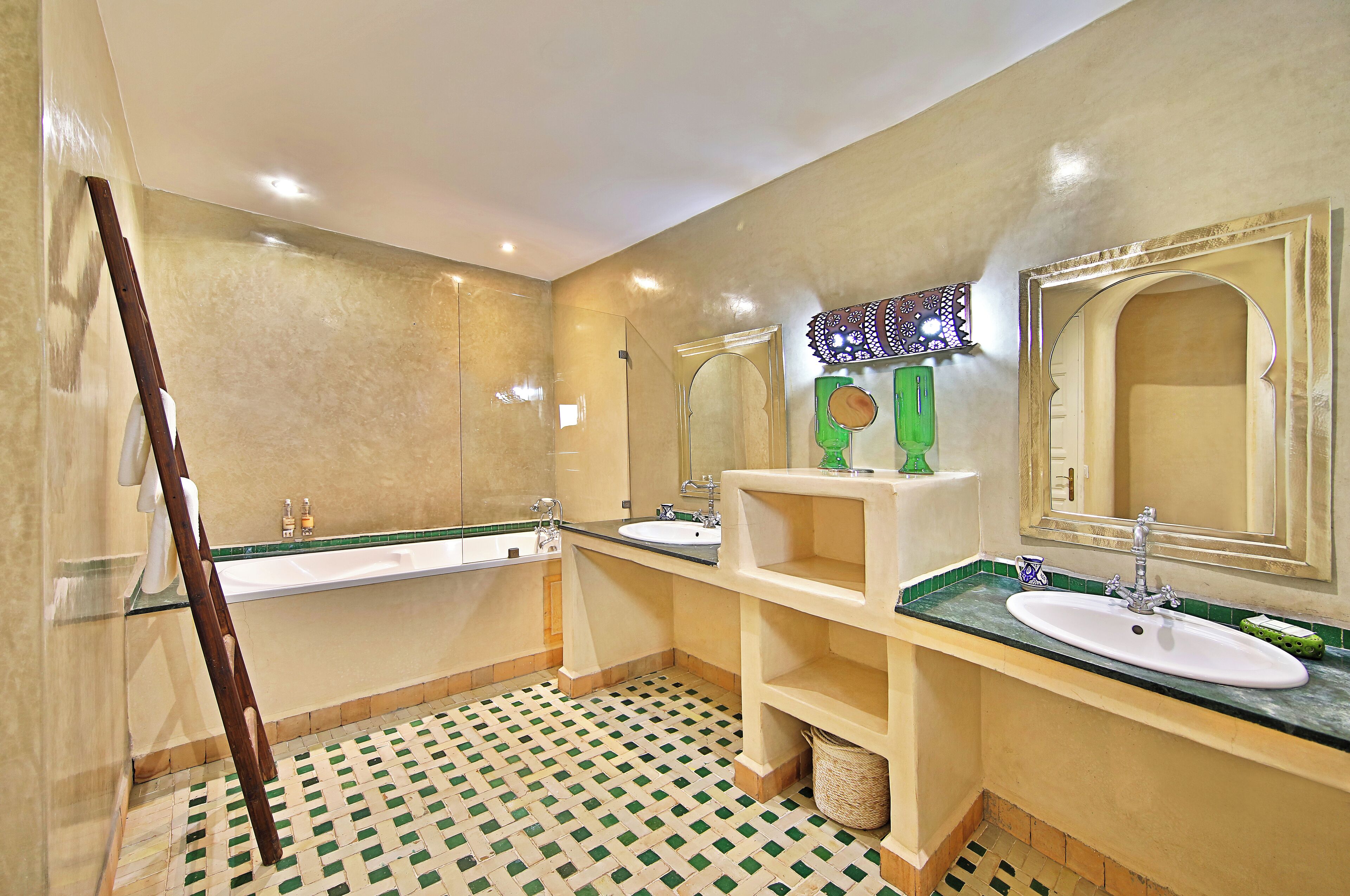 A bathroom with two sinks, a bathtub, and a mirror.