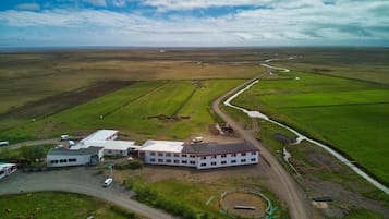 Rural retreat surrounded by expansive green fields and a winding road.