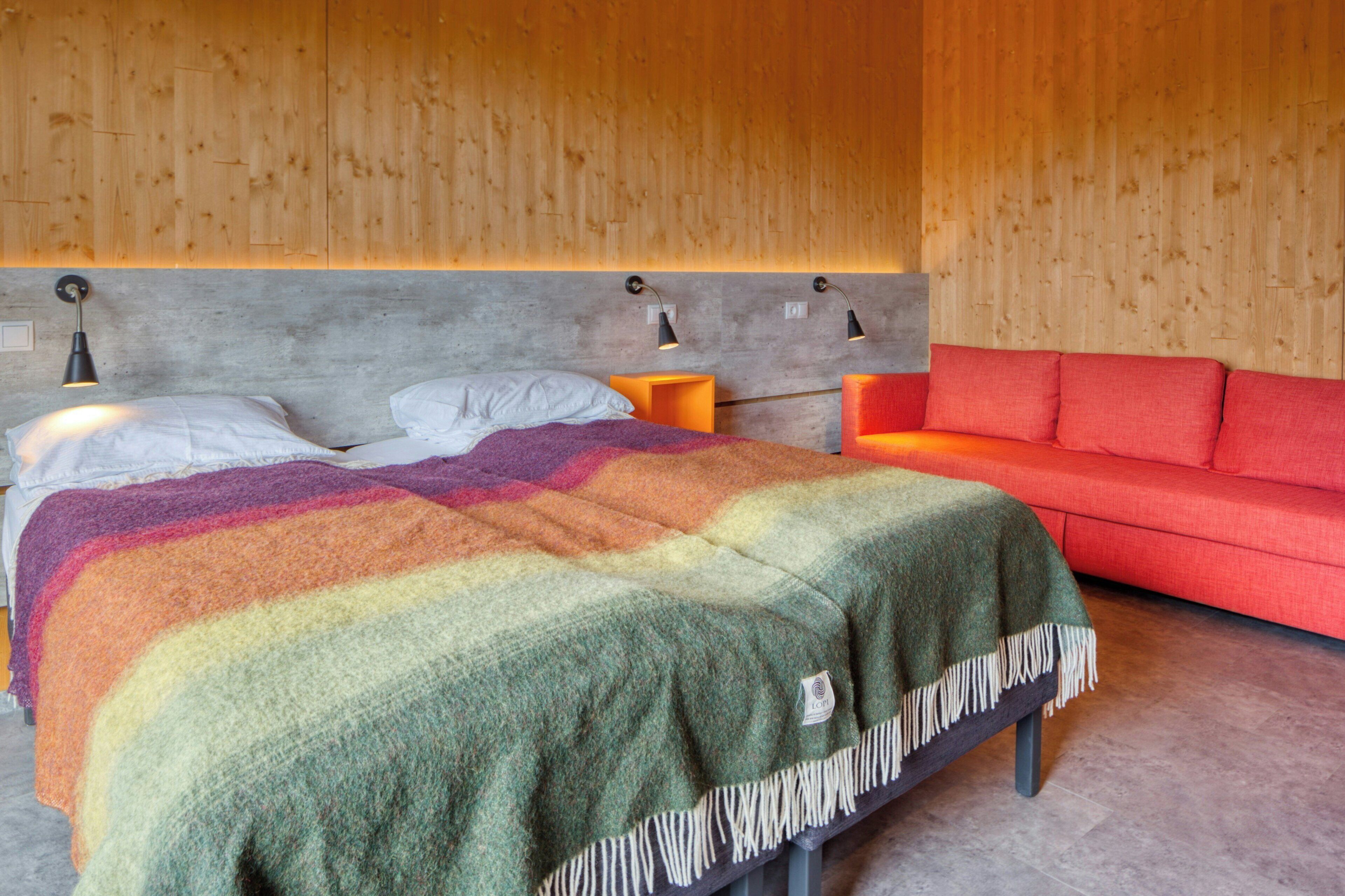 Une chambre à coucher avec un lit, un canapé rouge et deux tables de chevet avec des lampes.