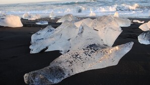 Large ice formations on a beach with the ocean in the background. - Brunnhóll Country Guesthouse (Höfn)