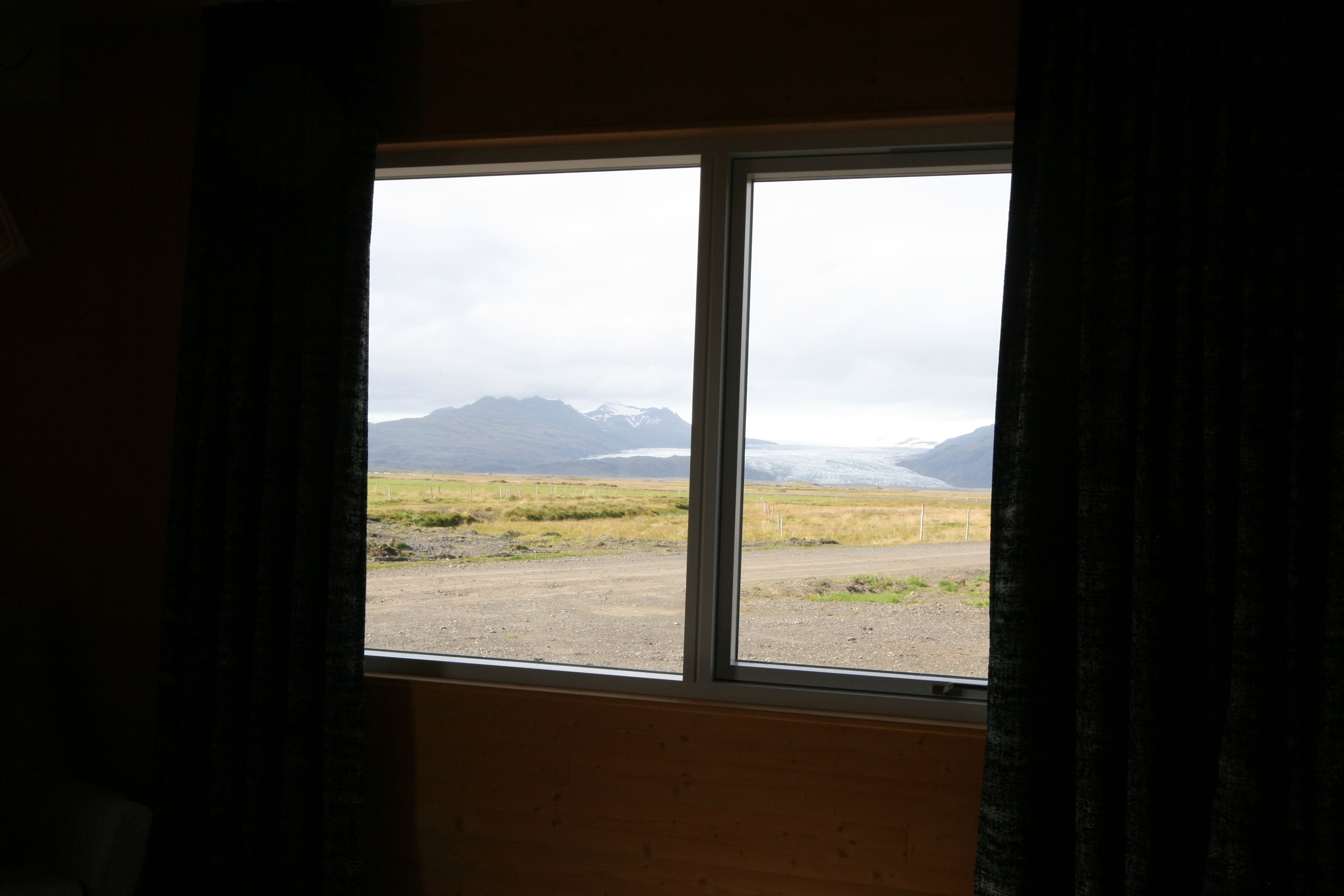 Una habitación con un ventanal amplio que da a un paisaje montañoso.