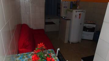 A compact kitchen with a refrigerator, a microwave, and a water dispenser.