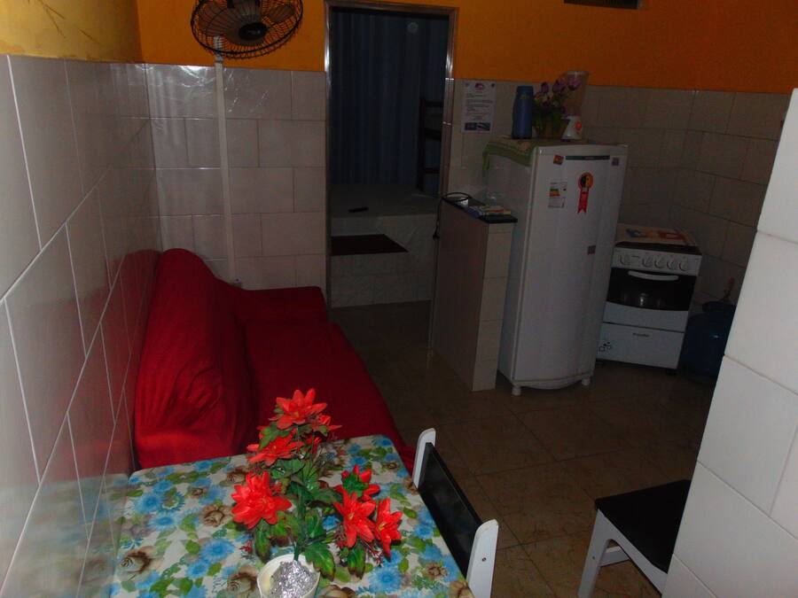 A compact kitchen with a refrigerator, a microwave, and a water dispenser.