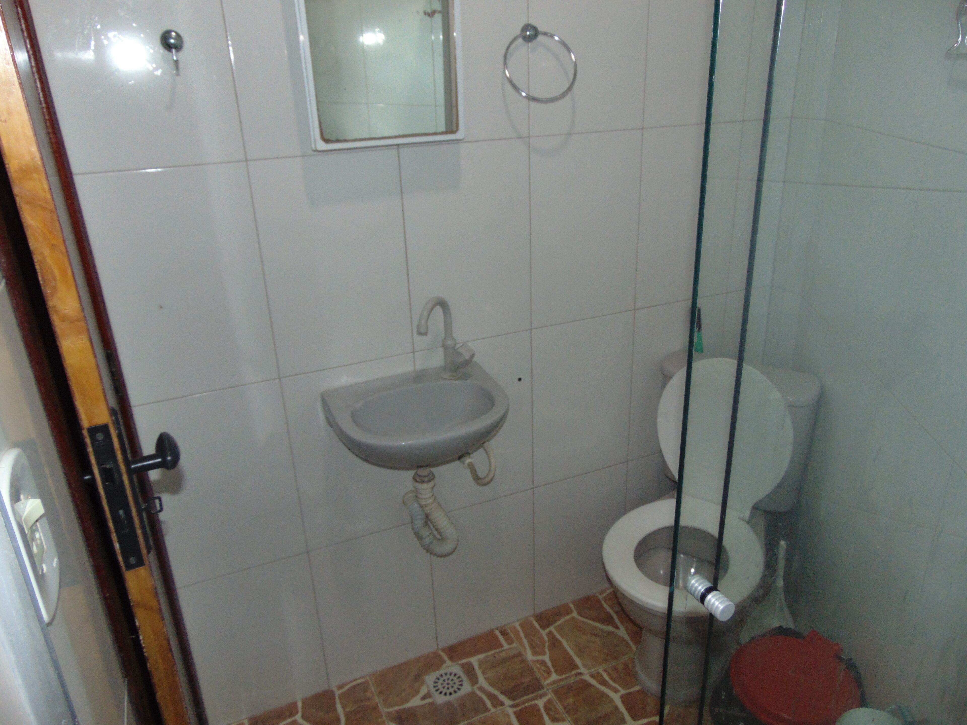 Casa de banho com lavatório, sanita e cabine de duche.