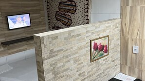 Uma casa de banho moderna com zona de duche, toucador com espelho e televisão na parede.