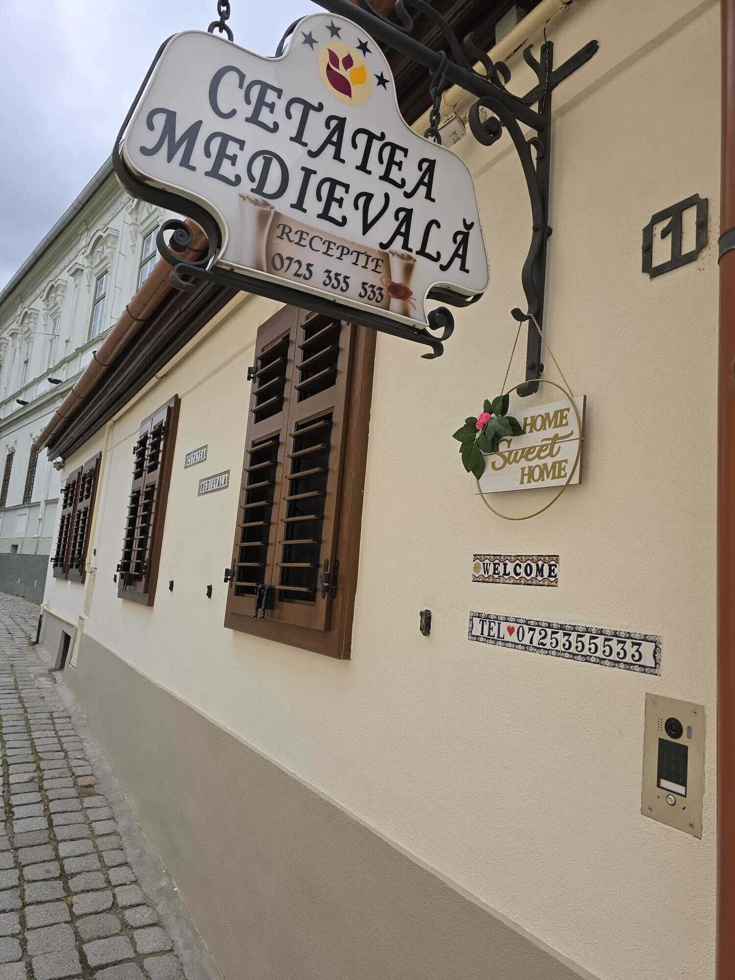 A building with a sign reading "CETATEA MEDIEVALĂ" and a "HOME Sweet HOME" sign.