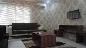Una sala de estar con un sofá, una mesa de centro y un mueble para televisión.