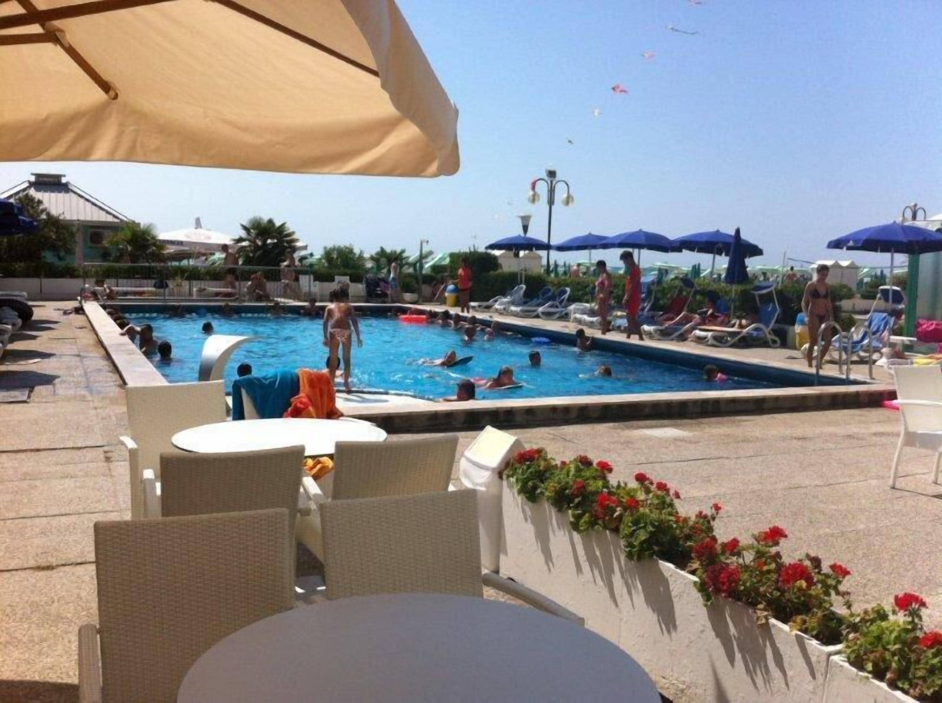 Una piscina al aire libre de temporada, sombrillas