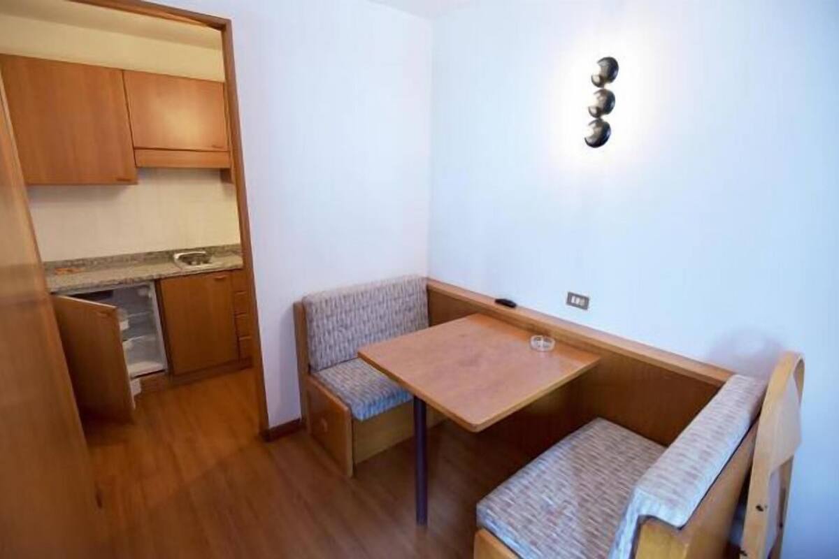A compact kitchenette with wooden cabinets and a countertop.