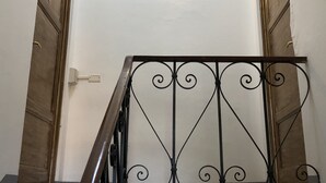 A staircase with a metal railing and wooden doors. - Relais Puccini (Lucca)