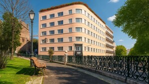 A multi-story hotel with a curved facade, a rooftop garden, and a paved walkway with benches. - Maxime Boutique Hotel Avenida da Liberdade (Lisbon)