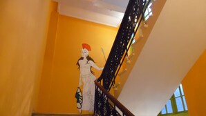 A staircase with a railing and a mural on the wall. - Zeus Hostel (Athens)