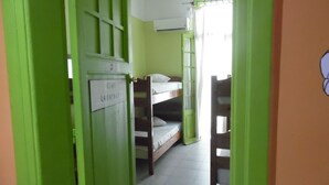 A room with bunk beds, a green door, and a white wall. - Zeus Hostel (Athens)