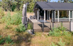 A modern house with a deck, outdoor seating, and a covered grill area. - Lovely home in Nexø with kitchen (Nexø)