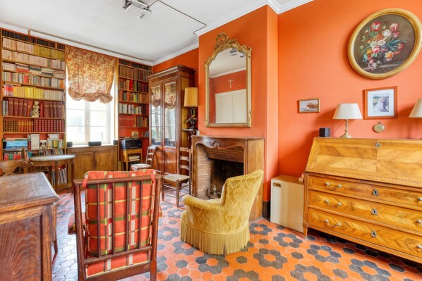 A room with a fireplace, a wooden bookcase, a mirror, and a wooden dresser.