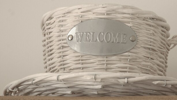 A wicker basket with a metal plate that reads "WELCOME". - Gordon House (Wimborne)