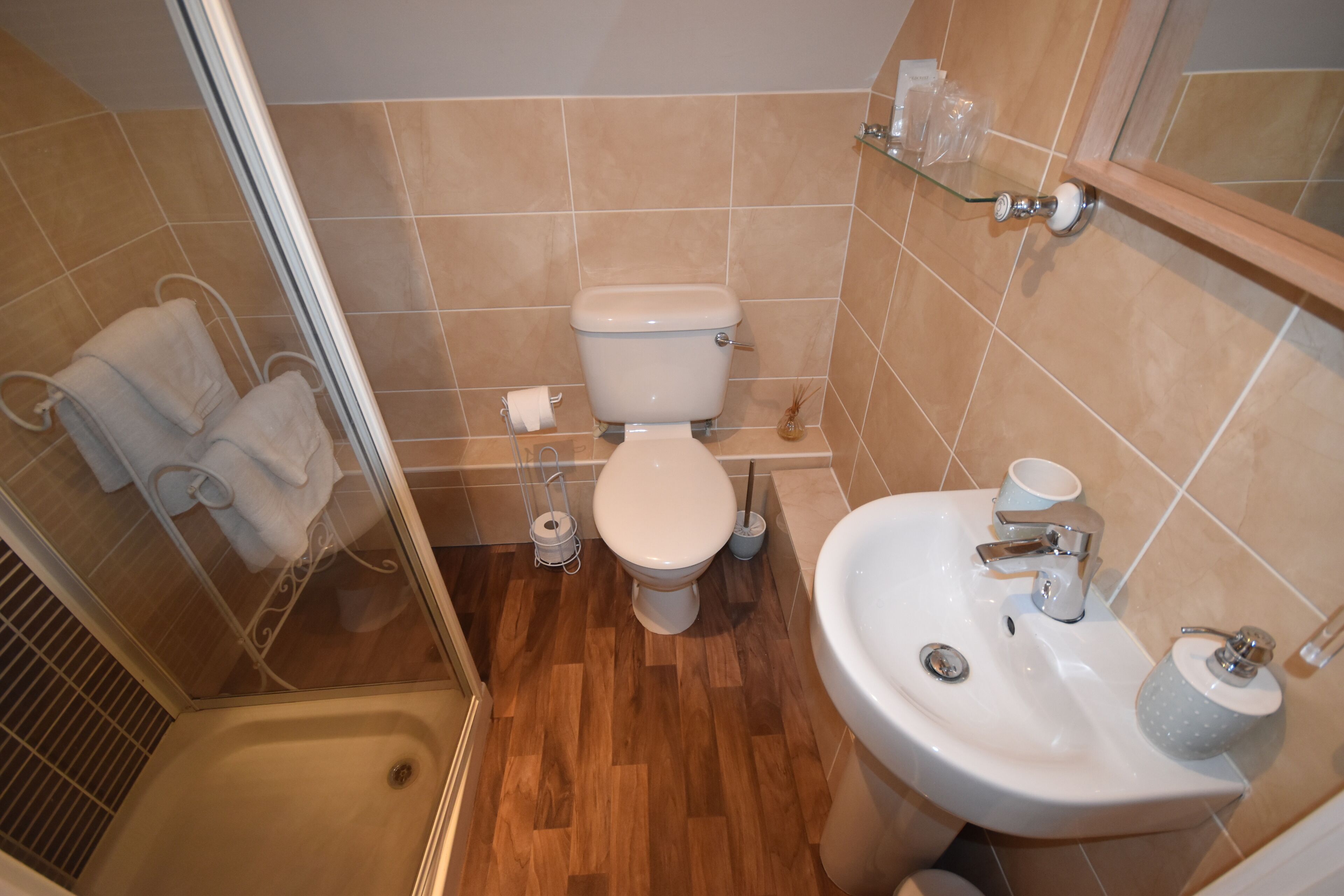 A bathroom with a toilet, sink, and shower.