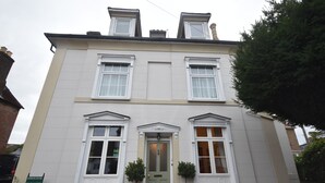 A two-story building with a symmetrical facade, a central entrance with a door, and two windows on each floor. - Gordon House (Wimborne)