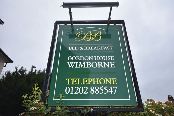 Señal para Gordon House Bed & Breakfast en Wimborne, que incluye un número de teléfono.