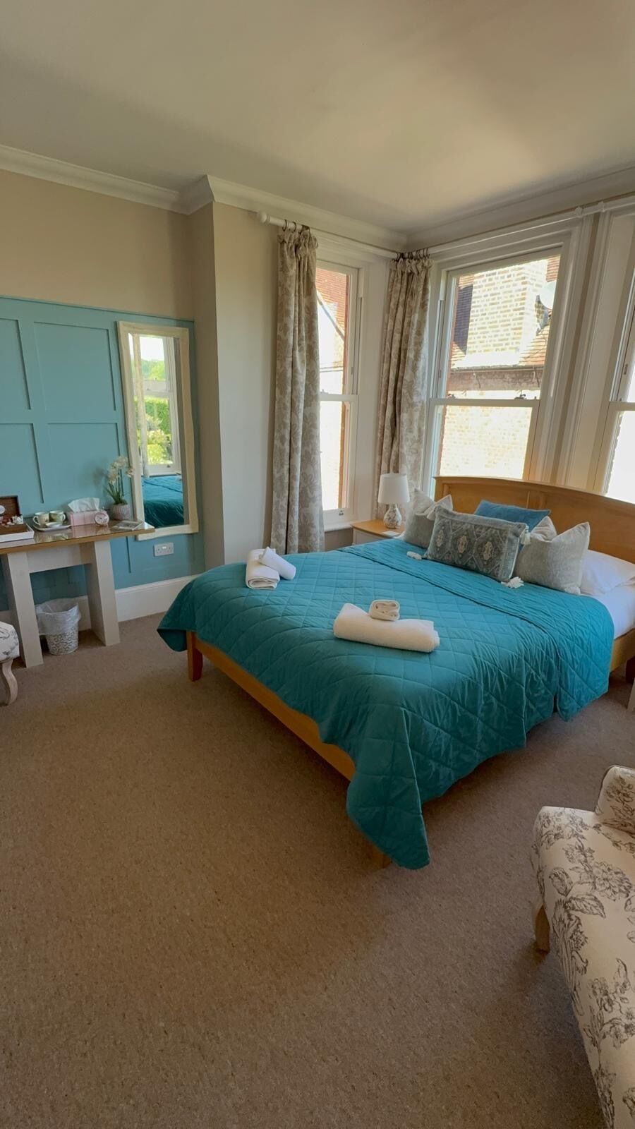 A bedroom with a bed, bedside table, and a window with curtains.