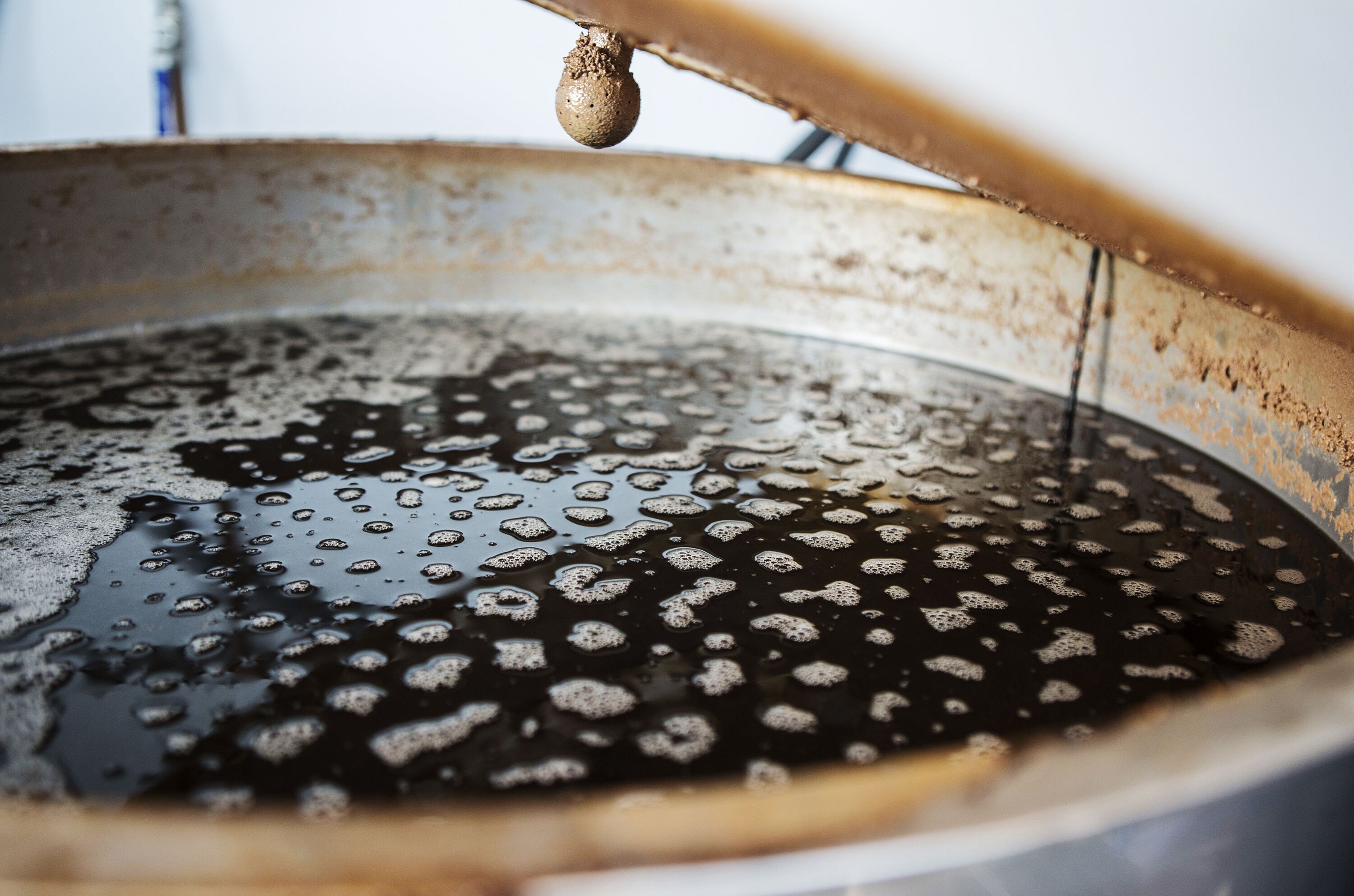 A close-up of a metallic pan with water droplets and a hanging object.