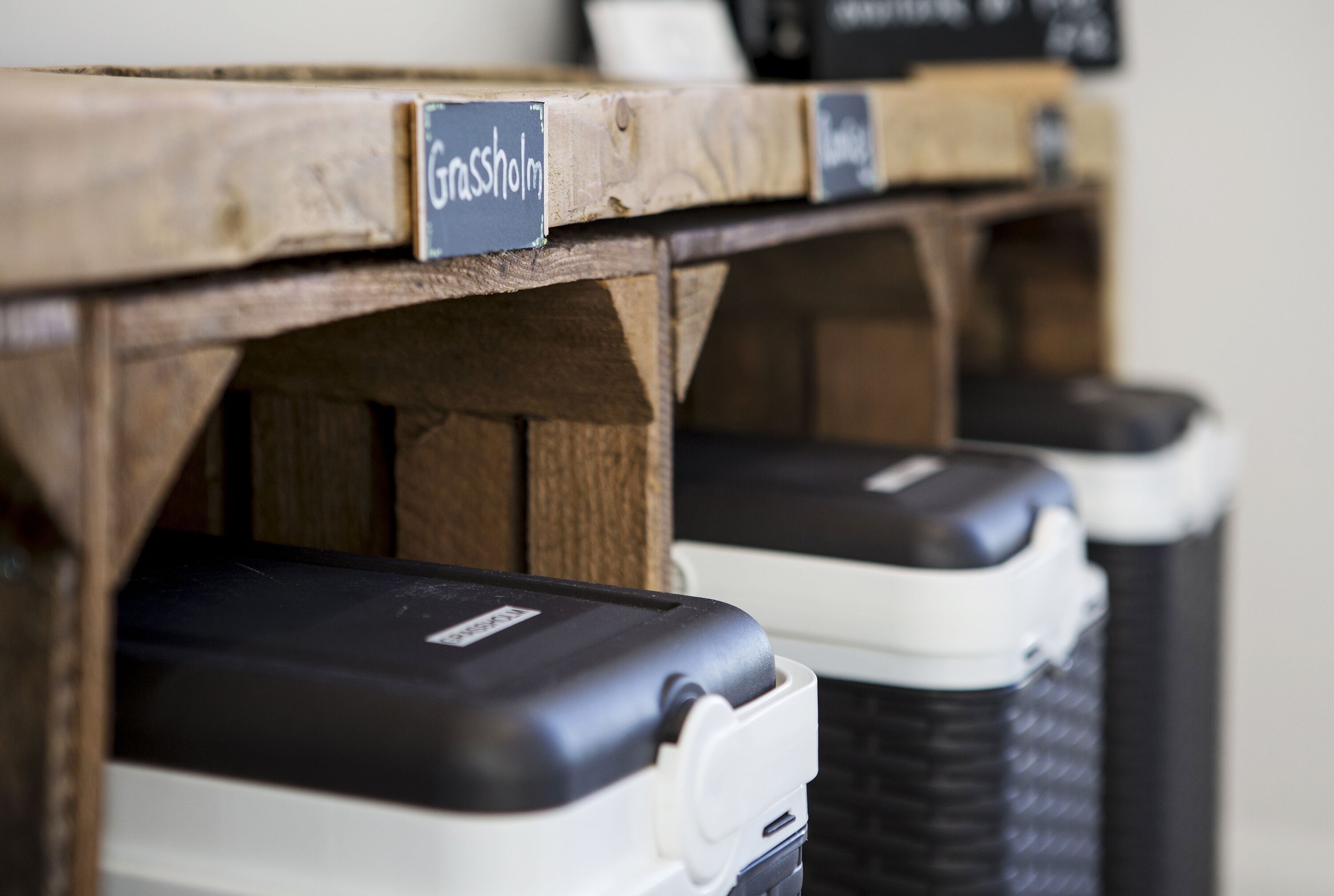 A row of trash bins with labels, including one labeled "Grassholm."