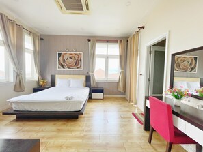A hotel room with a bed, bedside tables, a desk with a chair, a mirror, and a window with curtains. - Sealink Villas Phan Thiet Mui Ne (Phan Thiet)