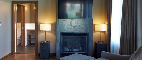 Una sala de estar moderna con chimenea, dos lámparas y un sofá.