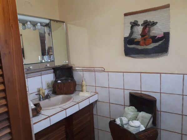 Une salle de bain équipée d’un lavabo, d’un miroir et d’un porte-serviettes.